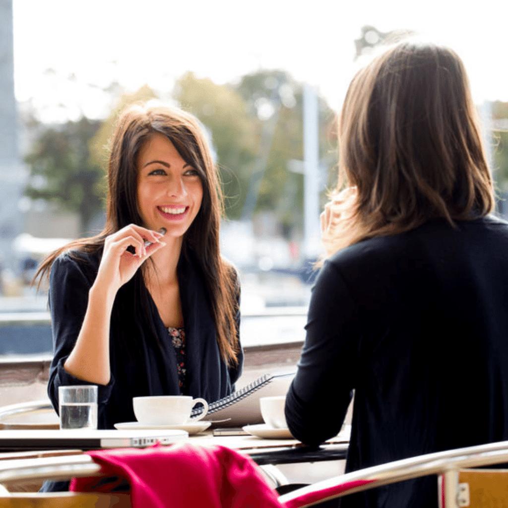to kvinner jobber og drikker kaffe ute